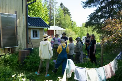 Permaculture Design Certificate participants standing in front of a passive solar air heater